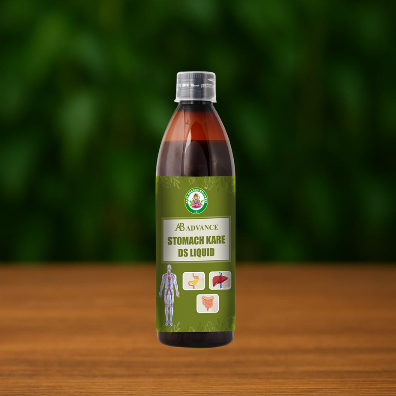 A brown plastic bottle labeled AB Advance Stomakk Kare DS stands on a wooden surface with a green leafy background. The label displays digestive system graphics and an illustration of a human body.